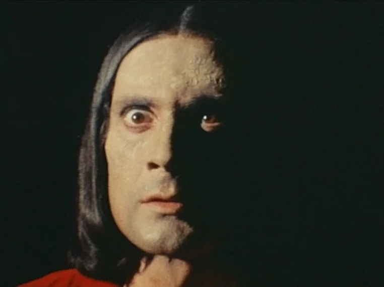 Salome (1972) movie still: closeup — A man's face emerges from total darkness into a pool of strong side lighting. The subject stares ahead with…