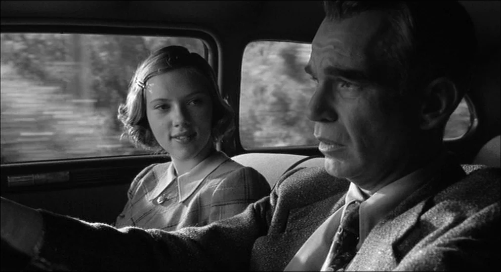 The Man Who Wasn’t There (2001) movie still: medium — A classic automobile interior with two passengers riding through a blurred landscape. An older…