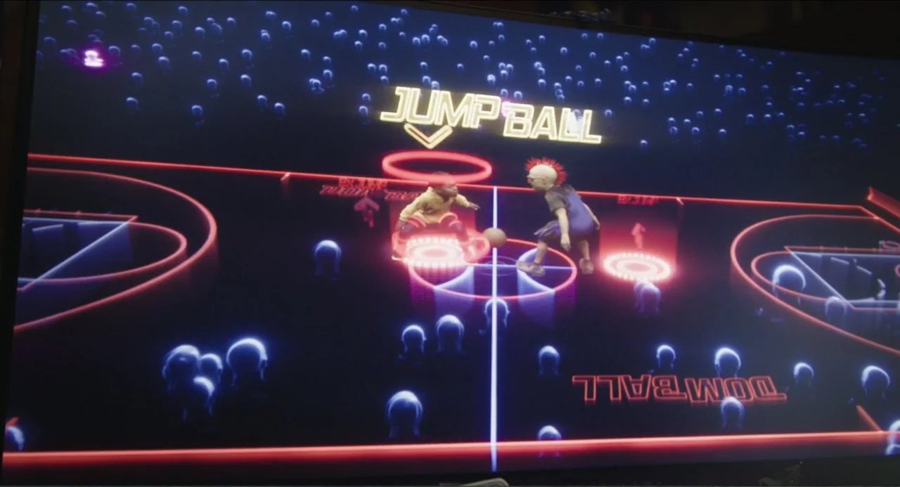 Space Jam: A New Legacy (2021) movie still: wide — A dark, stylized basketball court is defined by glowing red neon floor markings. Two players…