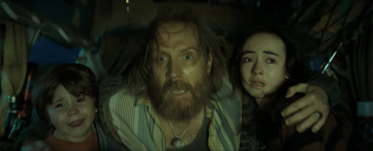 Venom: The Last Dance (2024) movie still: closeup — A dimly lit interior space with cluttered surroundings suggesting a cramped vehicle. A…