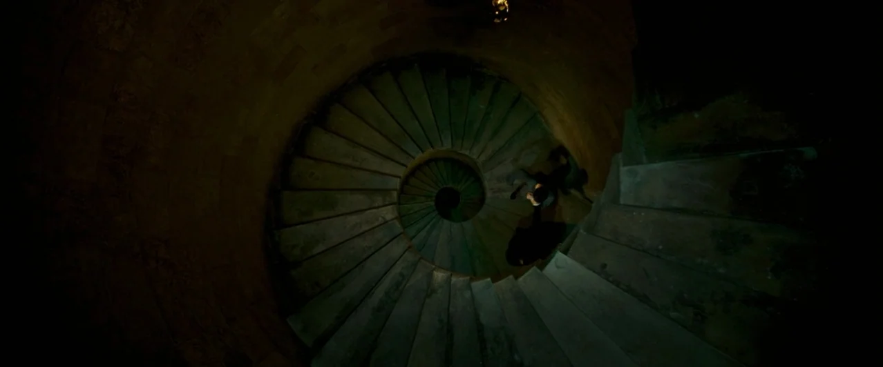 Harry Potter & The Order of the Phoenix (2007) movie still: wide — A stone spiral staircase descends into deep shadows with a central light source…