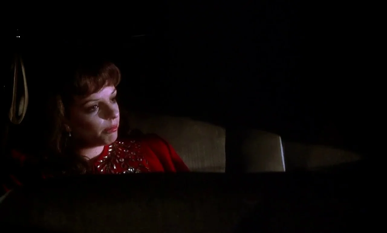 New York, New York (1977) movie still: medium — The interior of a car at night with a dark, indistinct background. A woman in a red beaded top sits…