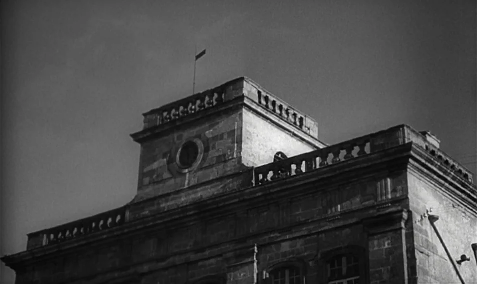 Thérèse Desqueyroux (1962) movie still: establishing — A stone building with a neoclassical roofline stands against an overcast sky. A small…