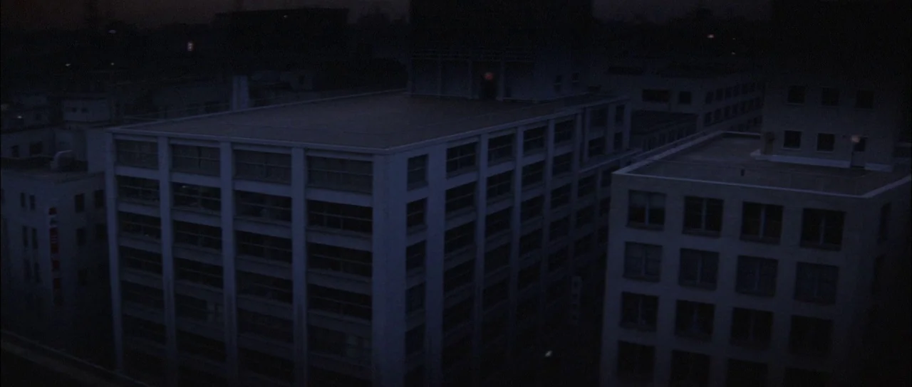 Ghidorah The Three Headed Monster (1964) movie still: establishing — A cluster of multi-story industrial buildings are viewed from an elevated night…