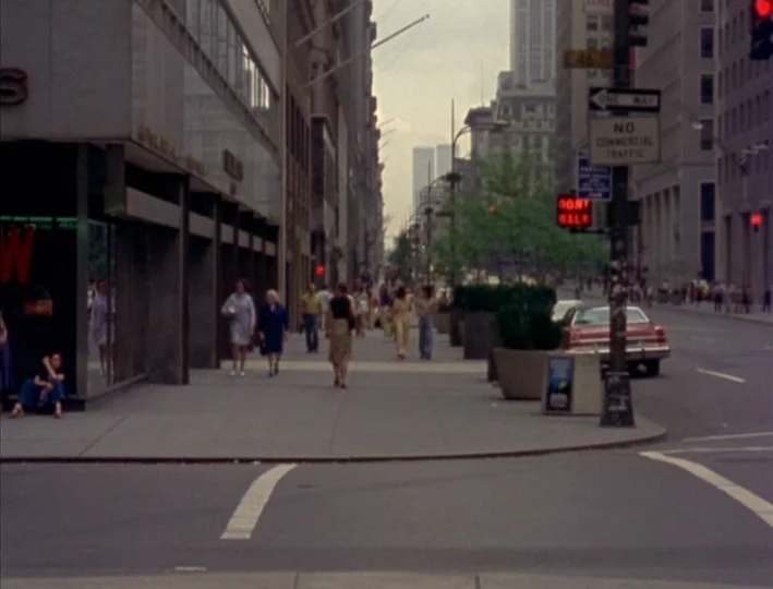 News From Home (1977) movie still: wide — A wide view of a New York City avenue with office buildings and pedestrians. People walk along the wide…
