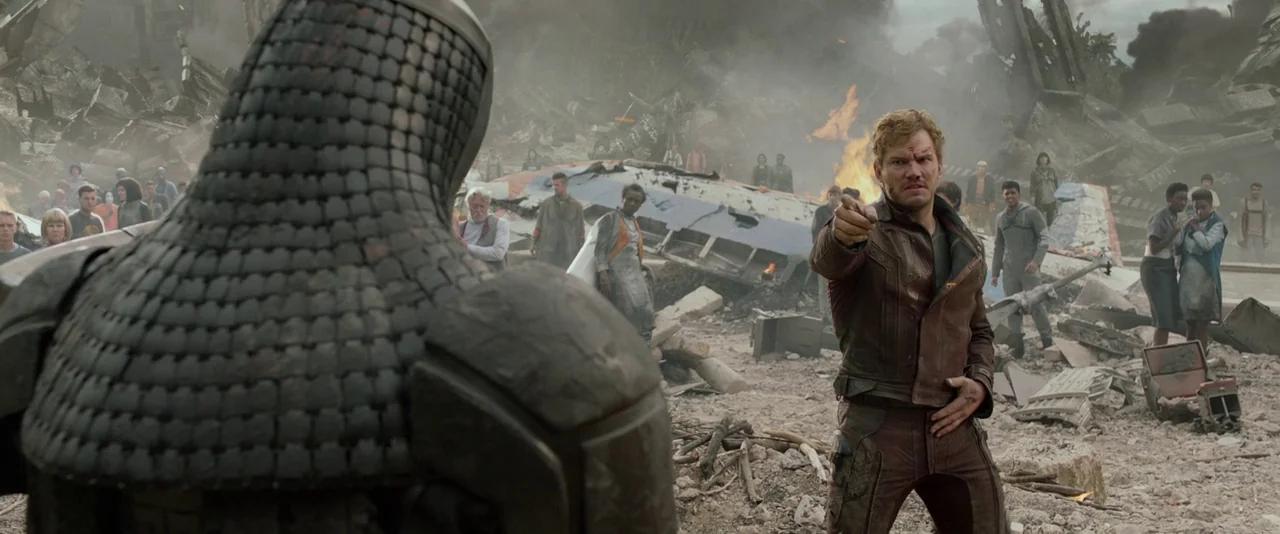 Guardians of the Galaxy (2014) movie still: medium — A decimated landscape features scattered rubble and fire beneath a dull gray overcast sky. A…