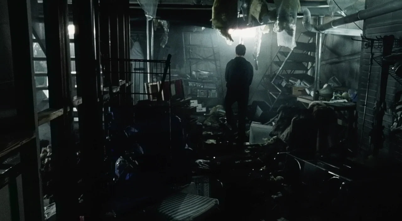 War of the Worlds (2005) movie still: wide — A dark, cluttered basement filled with boxes, loose insulation, and miscellaneous storage items. A man…