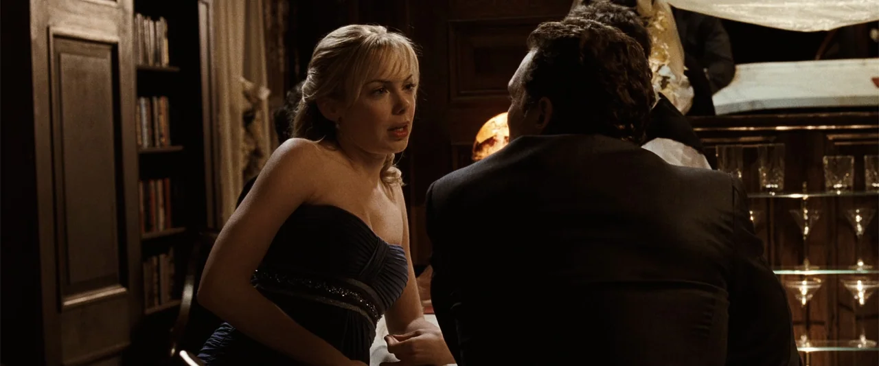 Ghosts of Girlfriends Past (2009) movie still: medium — A dimly lit upscale bar with dark wood shelving and glass drinkware in the background. A…