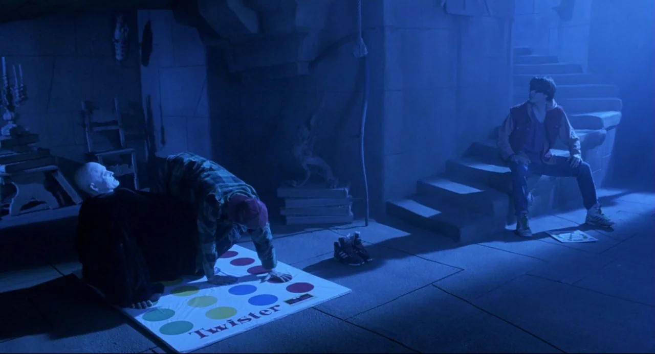Bill and Ted’s Bogus Journey (1991) movie still: wide — A stone-walled basement with a staircase in the background and low-hanging concrete beams.…