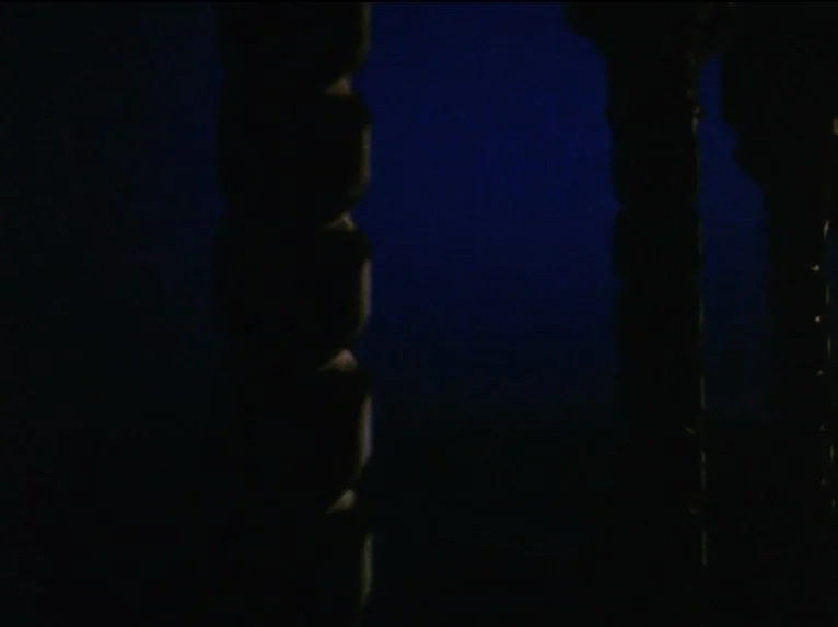 Our Lady of the Turks (1968) movie still: establishing — A dark, void-like space is divided by two thick vertical metal pillars. No subjects are…