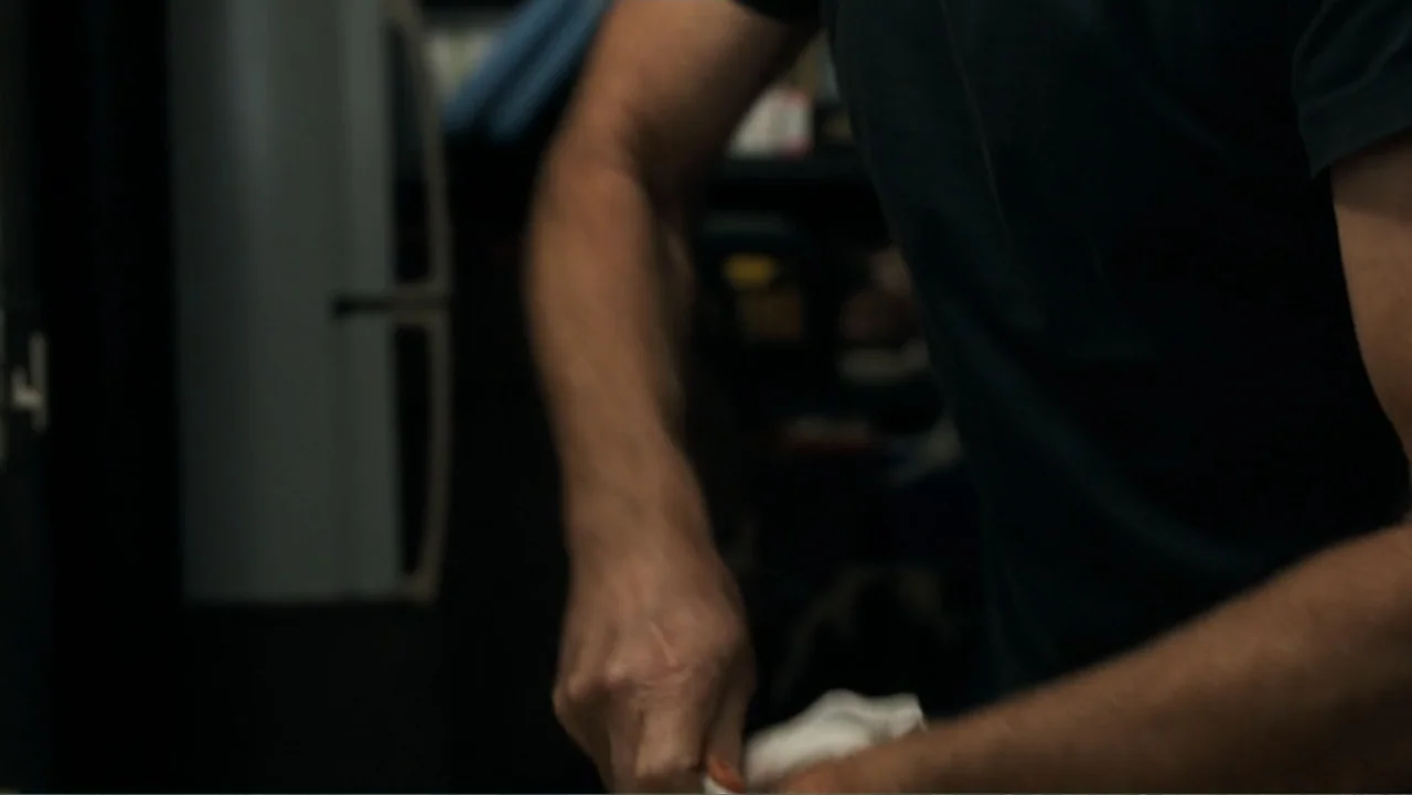 Death Wish (2018) movie still: medium — A dimly lit kitchen interior shows a refrigerator in the background blurred out of focus. A man in a dark…