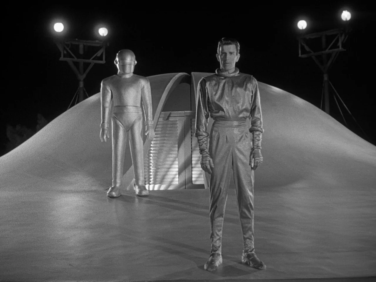 The Day the Earth Stood Still (1951) movie still: fullbody — A smooth, metallic dome-shaped vessel sits on a dark, level landing site at night. A…