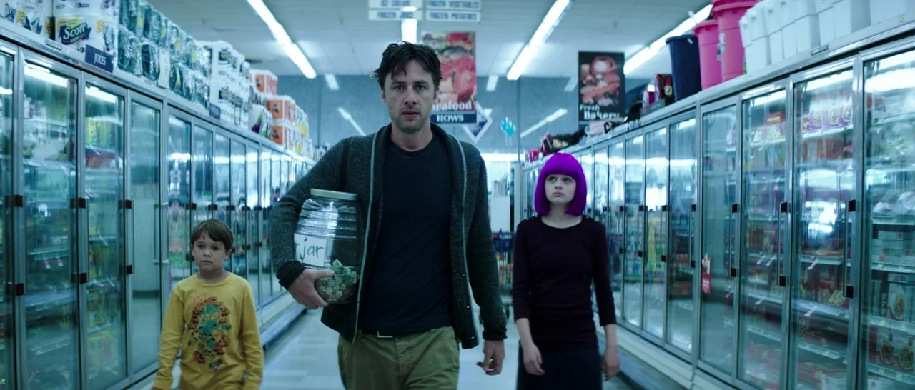 Wish I Was Here (2014) movie still: medium — A man and two children walk down the central aisle of a supermarket freezer section. Rows of…