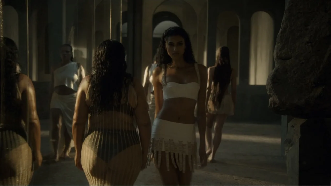 Victoria's Secret: The Tour '23 (2023) movie still: medium — A stone hall with multiple archways features several women walking between the pillars.…