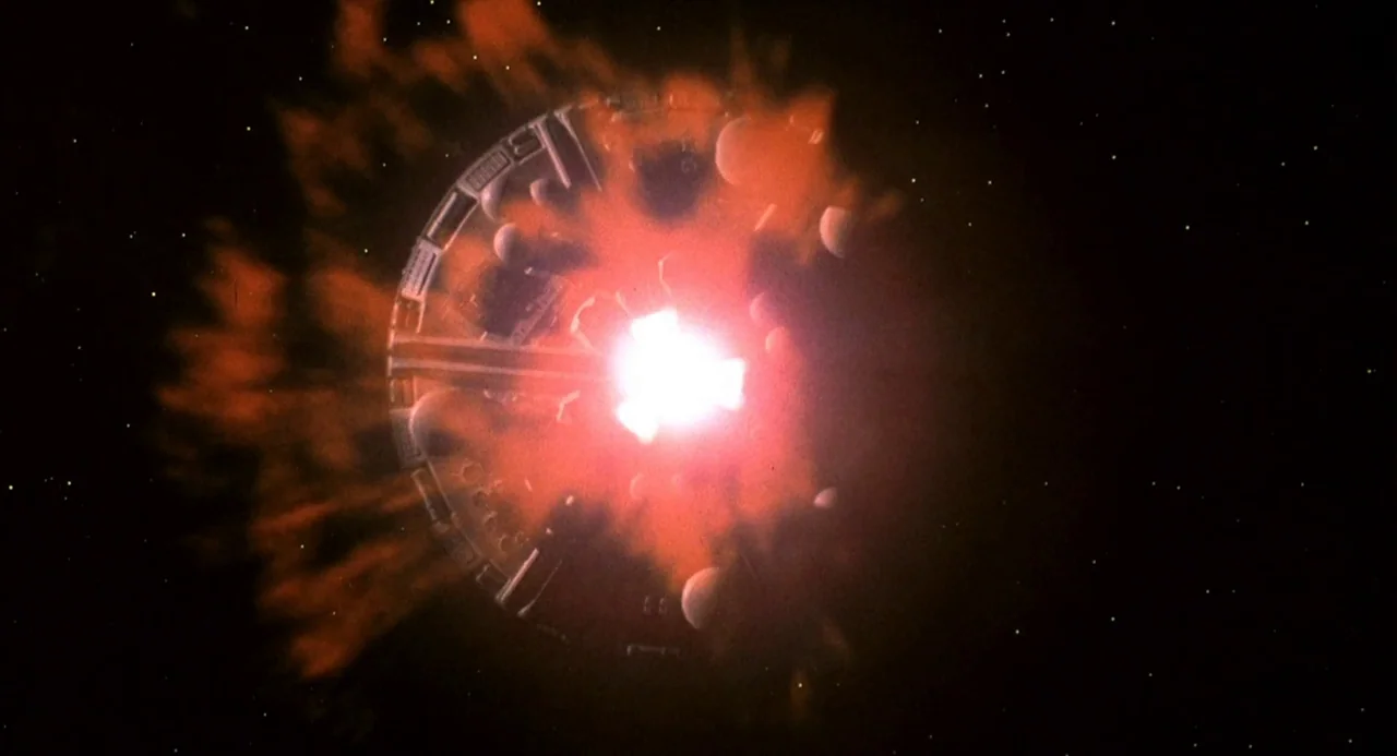 Silent Running (1972) movie still: wide — A circular modular space station floats in the dark void of outer space. A massive orange and red…