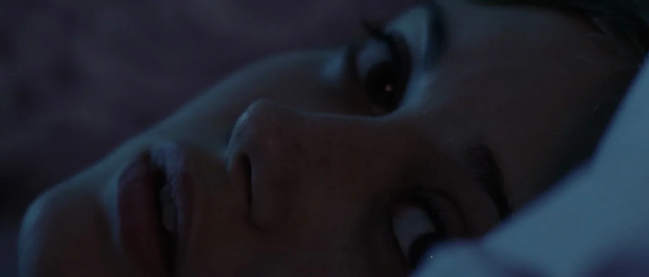 Wildlike (2014) movie still: closeup — A close-up of a person resting on a pillow in a dark room. The subject's face is partially obscured by…