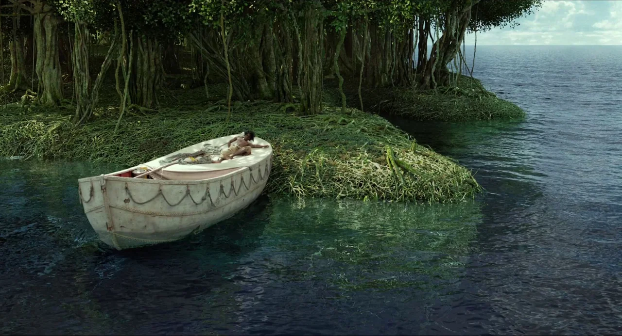 Life of Pi (2012) movie still: wide — A small white lifeboat rests against a tangled, root-covered shore of a remote island. A lone person lies…