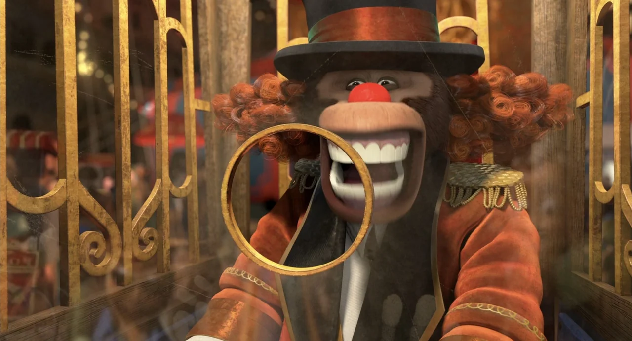 Madagascar 3: Europe's Most Wanted (2012) movie still: closeup — A monkey wearing a circus clown costume looks through a metal ring. The setting is…