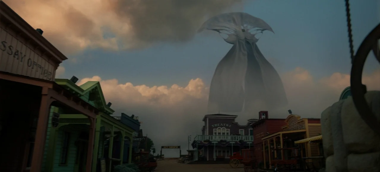 Nope (2022) movie still: wide — A quiet western town street features wooden storefronts with a theater and assay office. A massive translucent…