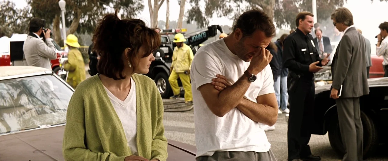 The Last Boy Scout (1991) movie still: medium — An outdoor car accident site with emergency personnel and tow trucks in the background. A man and a…