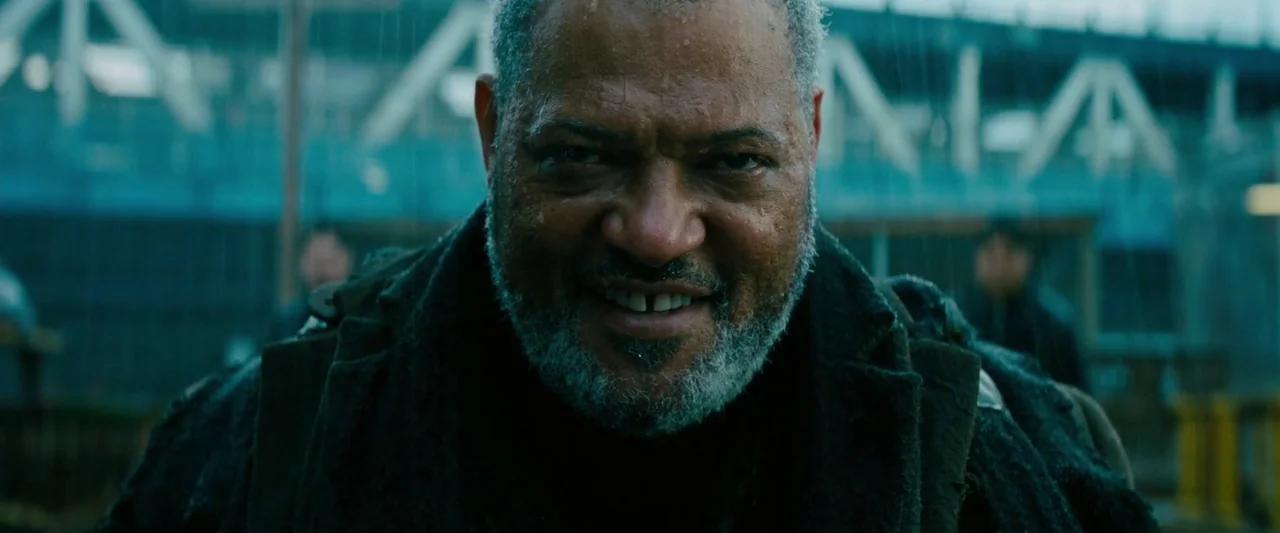 John Wick: Chapter 3 – Parabellum (2019) movie still: closeup — An outdoor urban location with heavy rain falling over a metal bridge structure. A…
