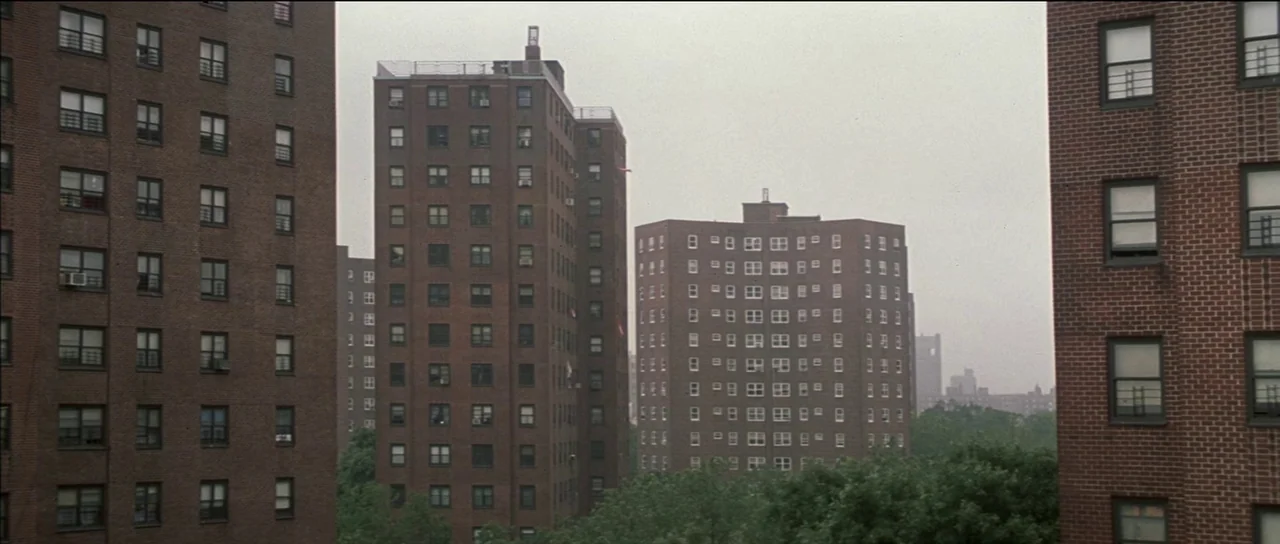 Finding Forrester (2000) movie still: establishing — Multiple red brick high-rise apartment buildings stand close together amidst clusters of green…