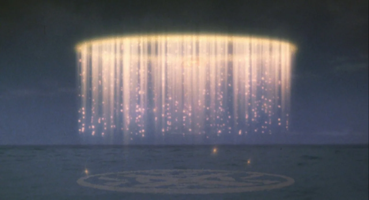 Godzilla and Mothra: The Battle for Earth (1992) movie still: establishing — A dark night scene shows a circular ring of light beaming down onto the…