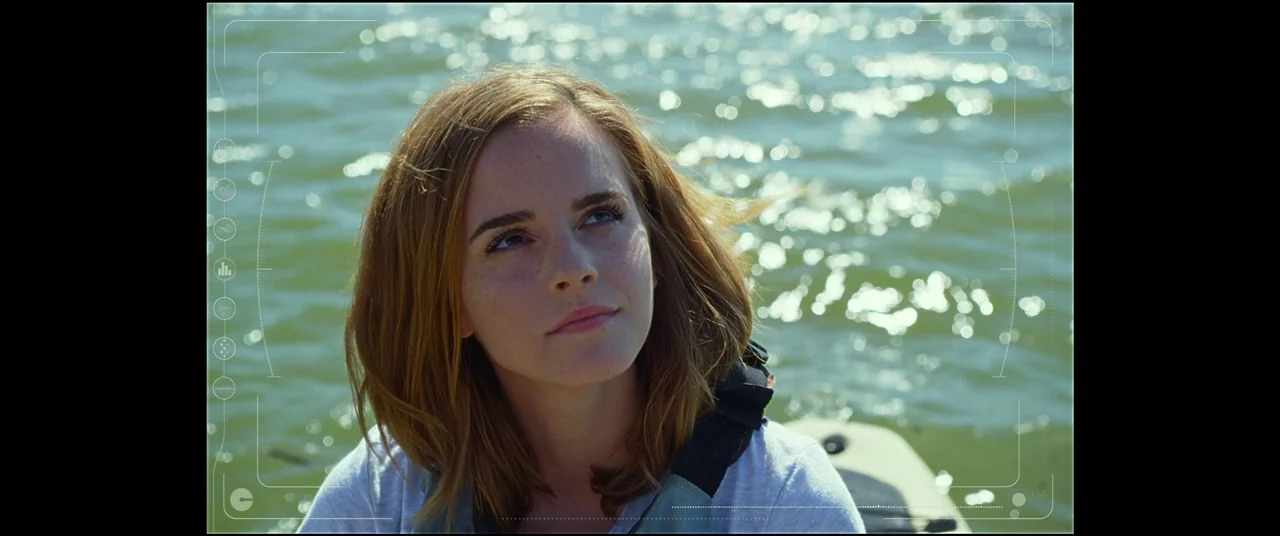 The Circle (2017) movie still: closeup — An open body of water with sunlight glinting off the gentle waves. A woman in a life vest is positioned in…