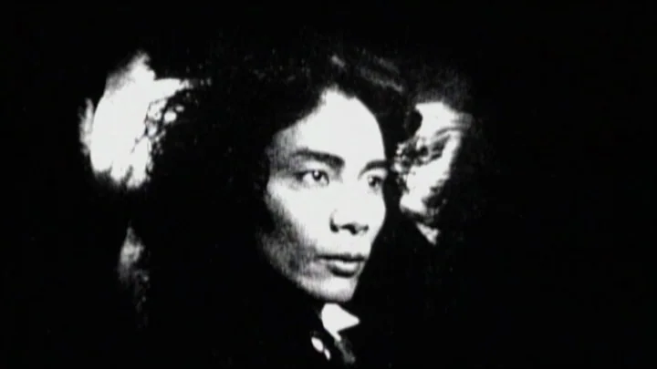 Dracula: Pages from a Virgin’s Diary (2002) movie still: closeup — A high-contrast, black-and-white close-up shot set against a pitch-black,…