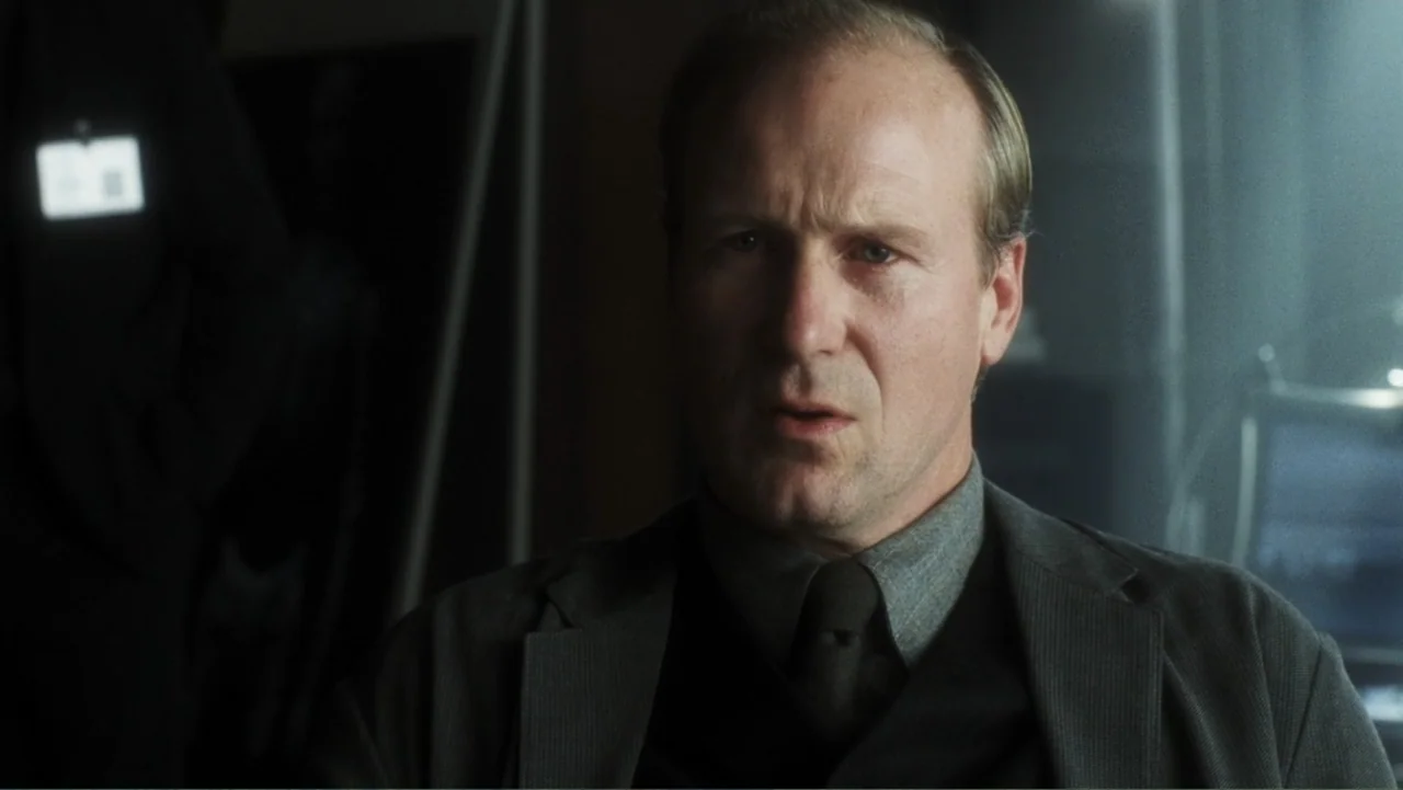 A.I. Artificial Intelligence (2001) movie still: medium — A modern, dimly lit professional office with a blurred background of workstation monitors.…