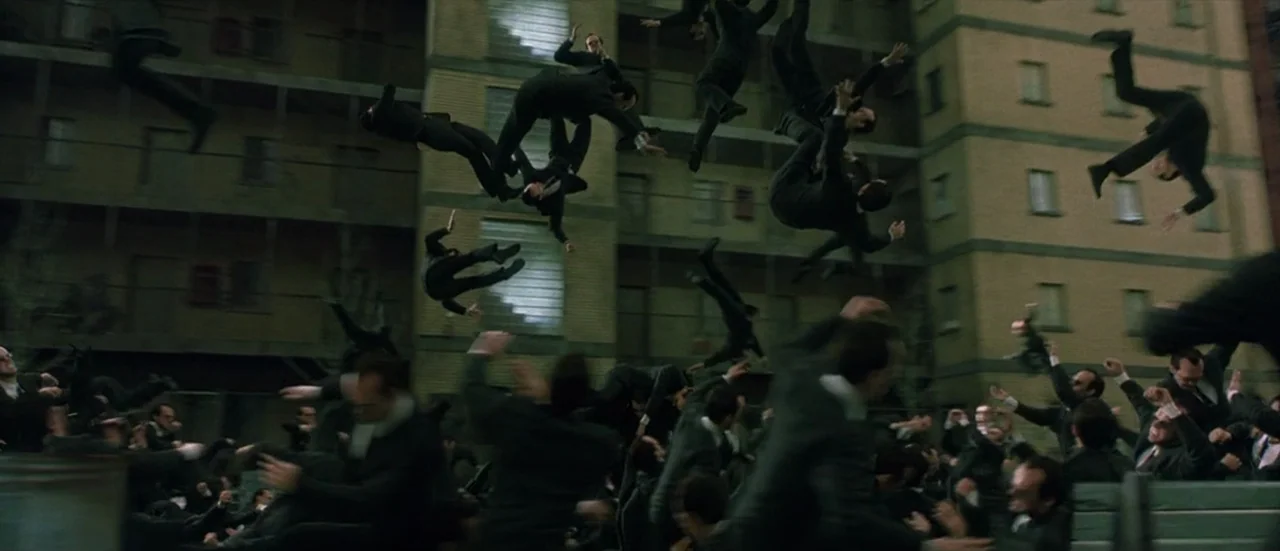 The Matrix Reloaded (2003) movie still: wide — An exterior courtyard of a multi-story apartment building features identical brick masonry walls.…