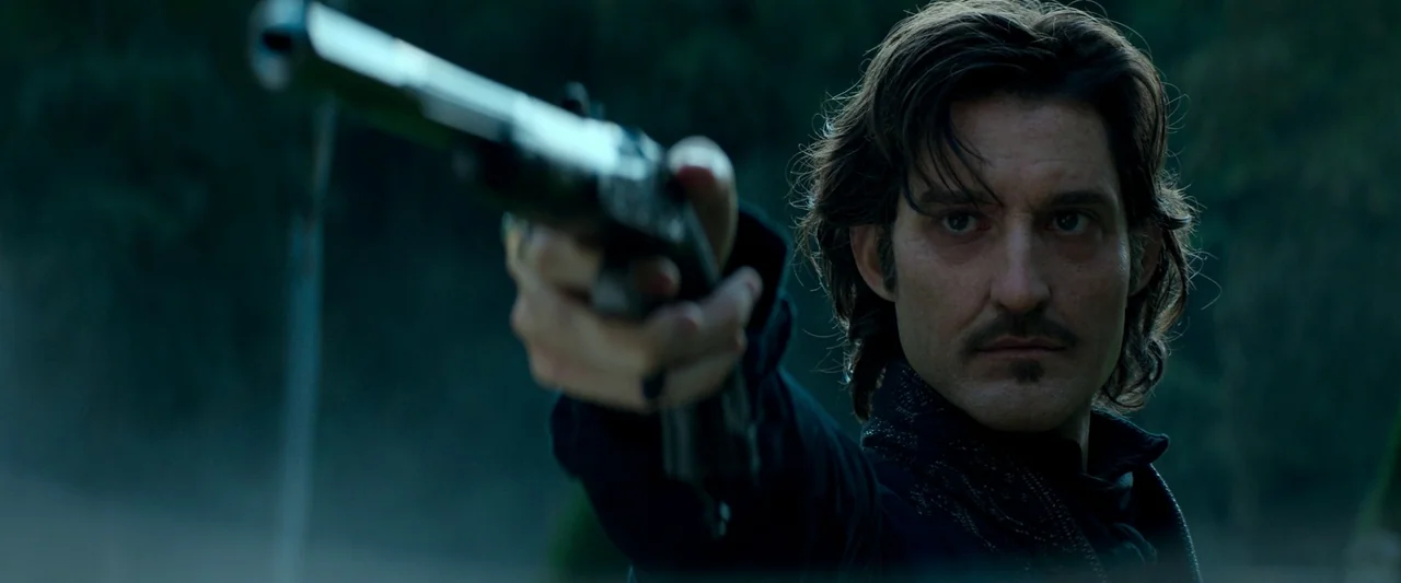 The Count of Monte-Cristo (2024) movie still: closeup — A dark, blurred outdoor setting with cool blue and green tones visible in the background. A…