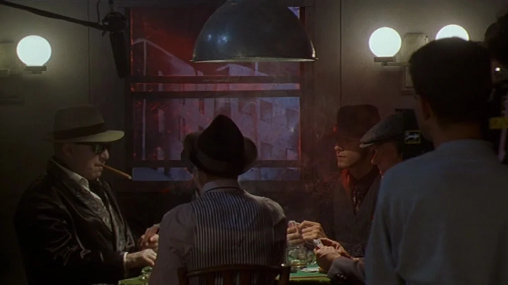One Hundred and One Nights (1995) movie still: medium — A dimly lit room with a card table in the center surrounded by men. A window in the back…