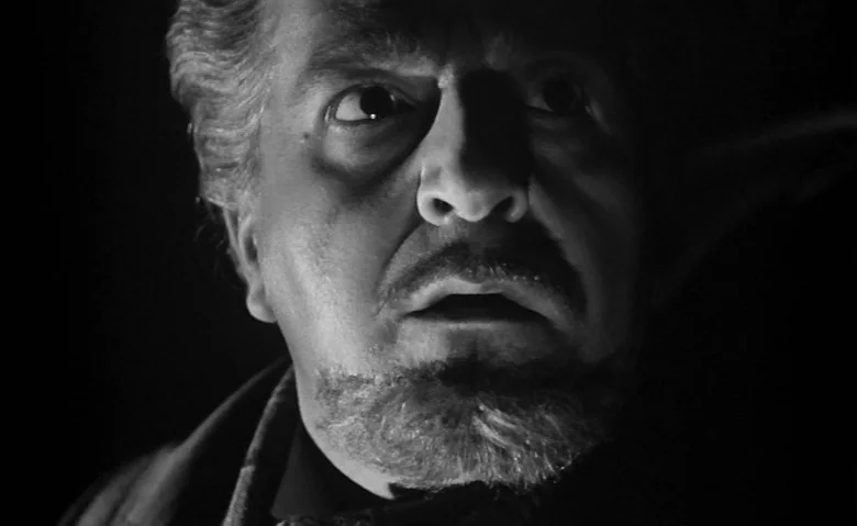 Black Sunday (1960) movie still: closeup — A dark, featureless environment surrounds a man's face in high contrast lighting. The man gazes toward…