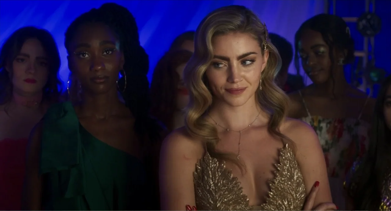 How to Date Billy Walsh (2024) movie still: medium — A crowded interior space illuminated by blue neon lighting with several people standing…