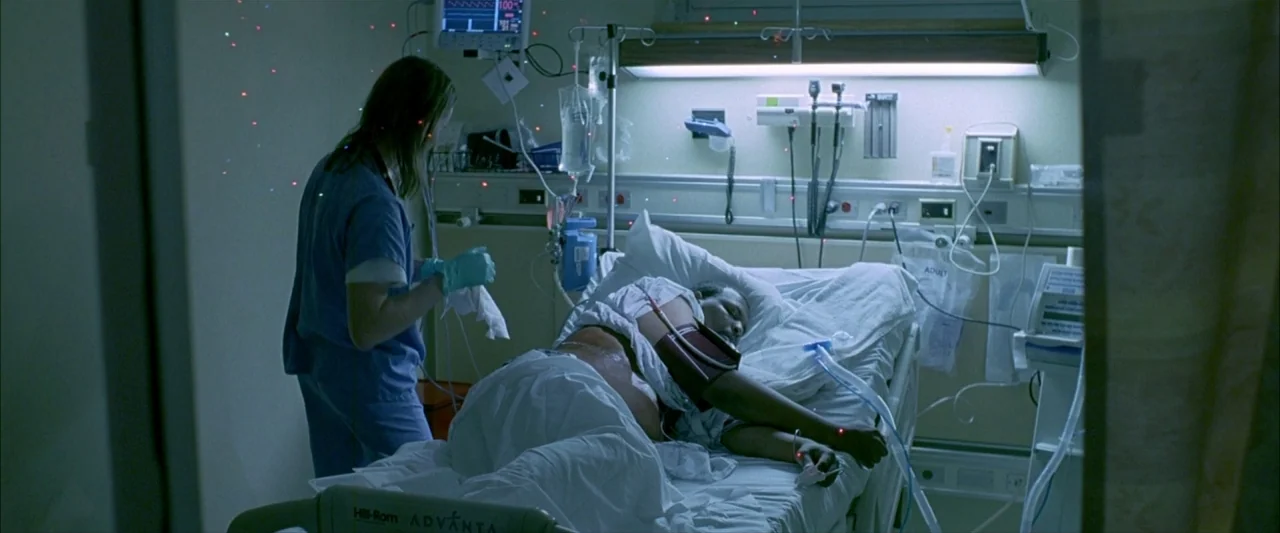 Ballast (2008) movie still: medium — A sterile medical room features a patient in a bed with assorted monitors. A nurse in scrubs stands at the…