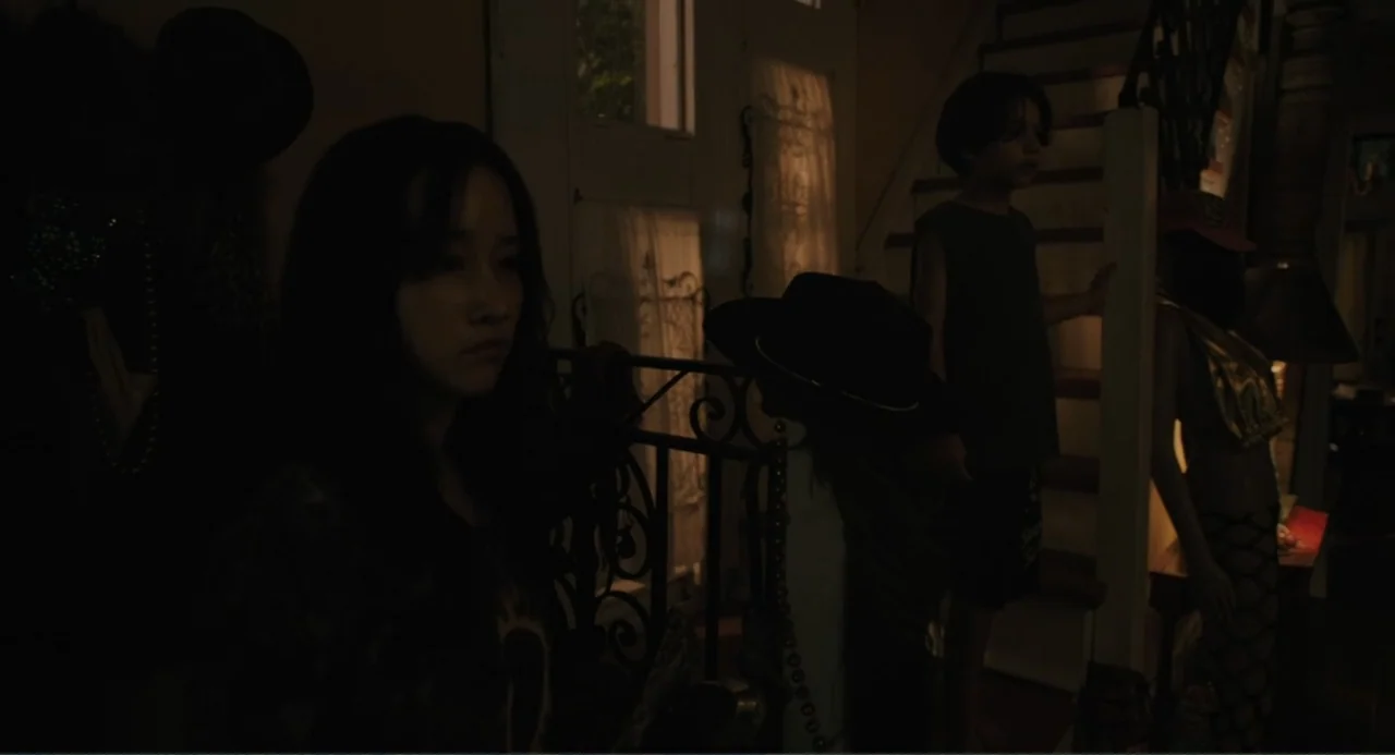 Mona Lisa and the Blood Moon (2022) movie still: medium — A dark interior staircase landing features an ornamental metal railing and window…
