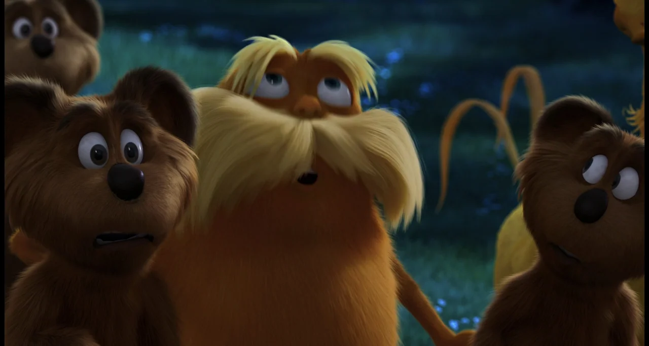 The Lorax (2012) movie still: medium — A group of furry creatures stands in a moonlit meadow at night. The orange creature with a large mustache…