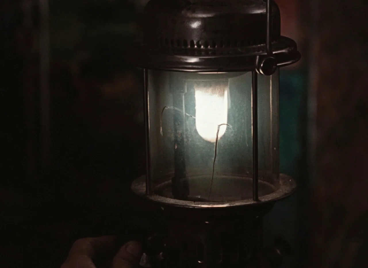 Pearls of the Deep (1965) movie still: closeup — A close-up view shows a metal-framed pressure lantern with a glowing white mantle inside. The…