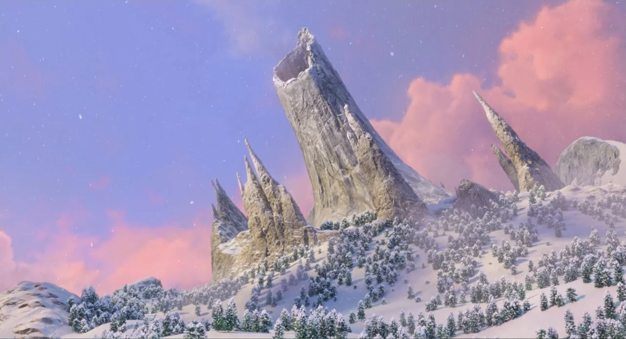 The Angry Birds Movie 2 (2019) movie still: establishing — A tall, jagged, spire-like mountain peak rises above a snowy landscape with small trees.…