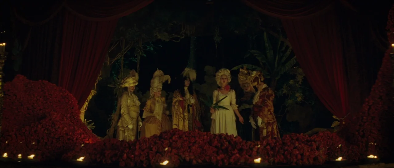 The Lost City of Z (2016) movie still: wide — A dimly lit stage features a group of individuals in ornate 18th-century court attire. They stand…