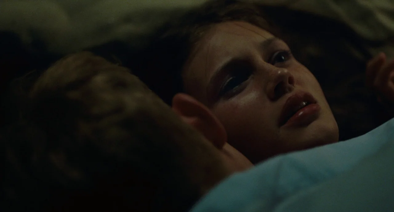 Young & Beautiful (2013) movie still: closeup — A dark bedroom with two people lying in bed together at night. A woman stares into the darkness…