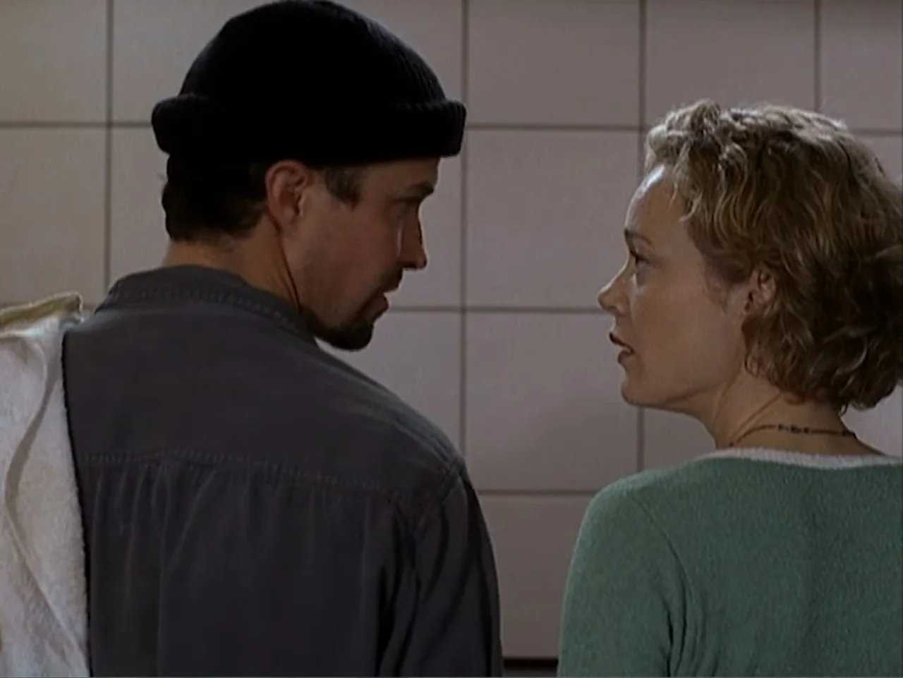 Catch a Falling Star (2000) movie still: medium — A tiled interior with square off-white wall tiles and a neutral color palette. A man wearing a…