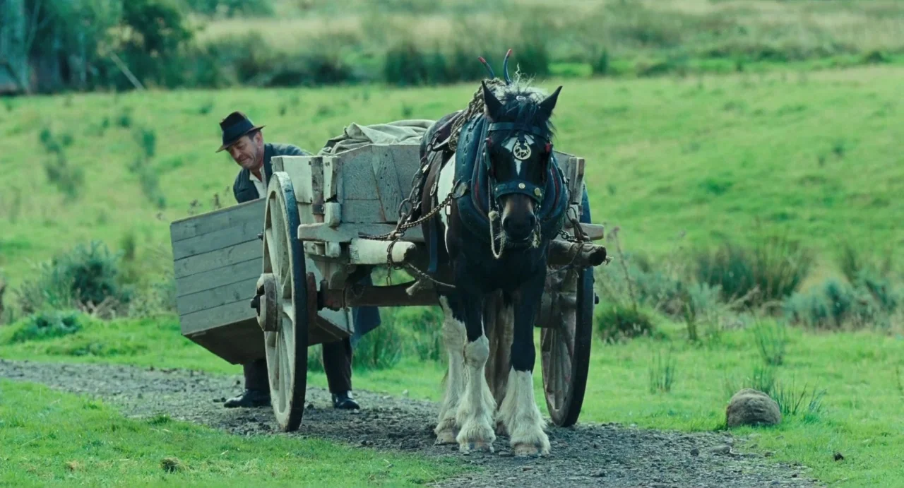 Jimmy’s Hall (2014) movie still: fullbody — A rural landscape featuring a dirt path flanked by rolling green pasture land. A man in period clothing…