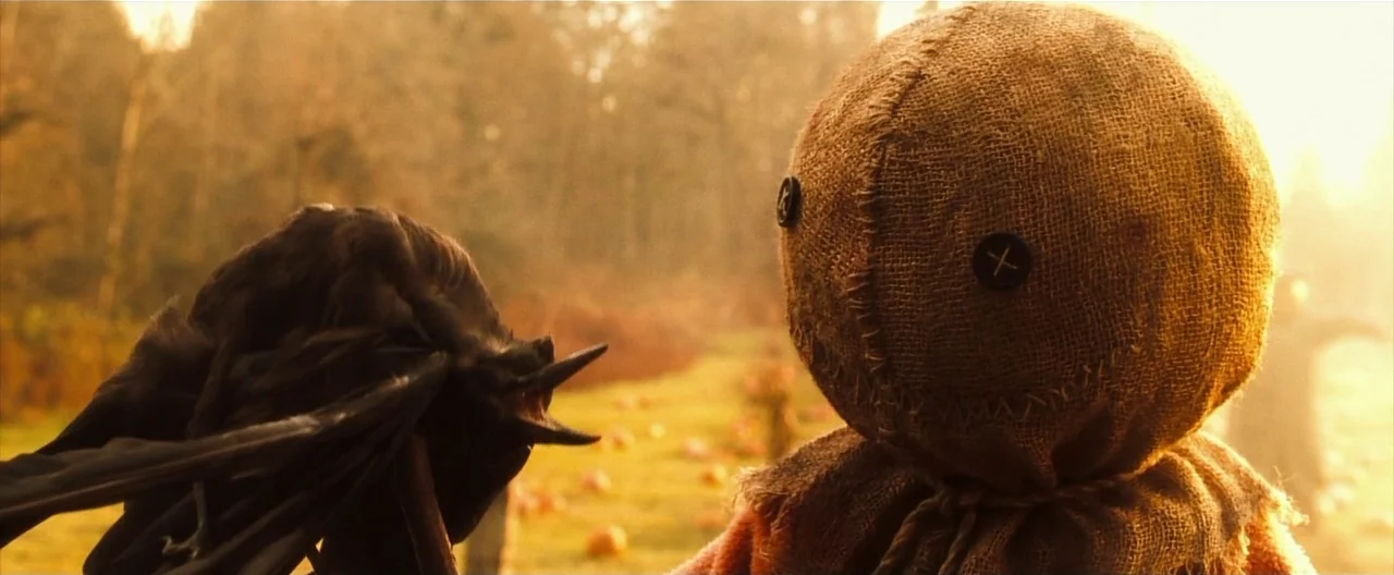 Trick ‘R Treat (2007) movie still: medium — An outdoor field is illuminated by the warm light of golden hour. A small creature with a burlap sack…