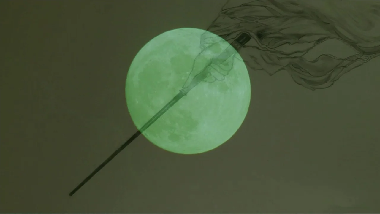 Empire Queen: The Golden Age of Magic (2024) movie still: closeup — A green circular moon fills the center of the frame against a muted background.…