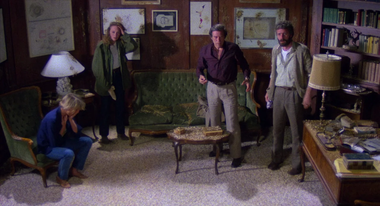 City of the Living Dead (1980) movie still: wide — A wood-paneled room is filled with framed sketches and bookshelves. Four people stand near a…