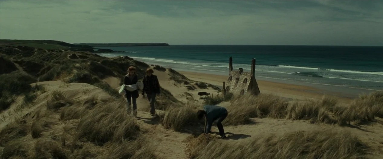 Harry Potter & The Deathly Hallows Part 1 (2010) movie still: wide — A desolate coastal landscape with rolling sand dunes overlooking a wide ocean…