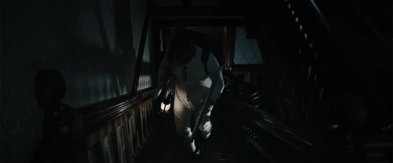 Equation of Love and Tone Deafness (2015) movie still: medium — A dark, narrow wooden staircase inside an old house with vintage wallpaper. A person…