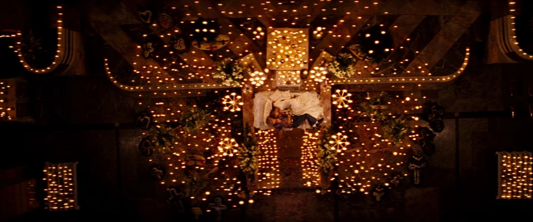 Romeo + Juliet (1996) movie still: establishing — A large stone floor is covered in thousands of lit candles and floral arrangements. A man and a…